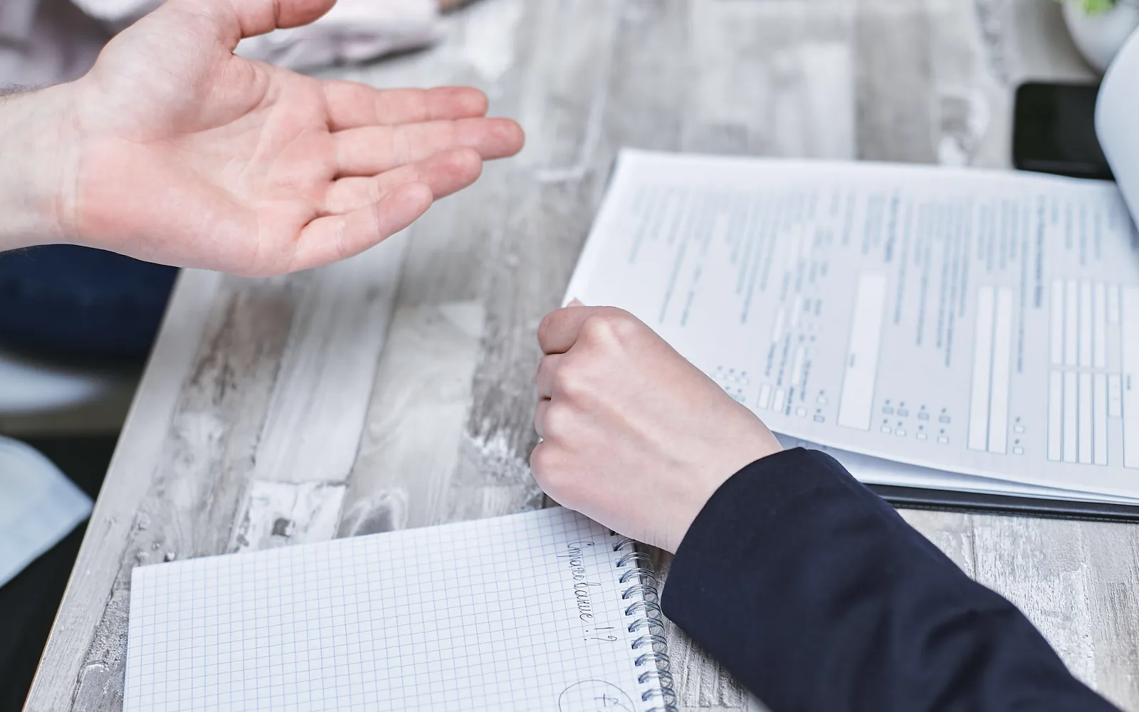 Two people reviewing printed documents at a table.